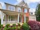 Charming two-story home showcasing a covered porch, manicured landscaping, and mixed siding at 18414 Victoria Bay Dr, Cornelius, NC 28031