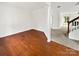 Open-concept living space with hardwood floors leading into a carpeted den and staircase at 18414 Victoria Bay Dr, Cornelius, NC 28031