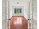 Home office with hardwood flooring, white trim, and natural light from a large window at 18414 Victoria Bay Dr, Cornelius, NC 28031
