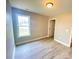 Bright bedroom featuring new flooring, a large window, neutral walls, and modern light fixture at 1872 Terrain Nw Dr, Conover, NC 28613
