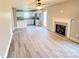 Open-concept room with fireplace, tile surround, ceiling fan, and kitchen in the background at 1872 Terrain Nw Dr, Conover, NC 28613