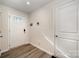 Welcoming entryway with wood-look flooring and a white front door with window pane detailing at 2037 Langer St, Charlotte, NC 28214