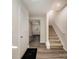 Bright hallway with wood floors, a staircase, and a view to the front door at 2037 Langer St, Charlotte, NC 28214