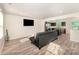 Bright living room with wood floors, a sleek couch, and an open view to the kitchen at 2037 Langer St, Charlotte, NC 28214