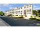 Attractive townhomes offer convenient garages, colorful doors, and neatly landscaped front yards along the street at 2037 Langer St, Charlotte, NC 28214