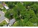 An aerial view of the property surrounded by mature trees in a residential neighborhood at 2255 Milton Rd, Charlotte, NC 28215