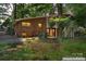 A backyard view of the two-story brick house featuring a small deck and a backyard surrounded by mature trees at 2255 Milton Rd, Charlotte, NC 28215