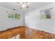 Bright bedroom with hardwood floors, two windows, and a ceiling fan at 2255 Milton Rd, Charlotte, NC 28215