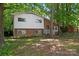 Inviting home featuring a mix of brick and siding, with a lush green lawn and surrounding trees at 2255 Milton Rd, Charlotte, NC 28215