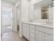 Bathroom with double vanity, white cabinets, and tiled floor with a glass door shower at 2588 Blue Sky Meadows Dr, Monroe, NC 28110
