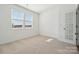 Bright, carpeted bedroom featuring large windows and a glass-paneled door for ample natural light at 2588 Blue Sky Meadows Dr, Monroe, NC 28110