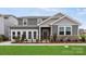 Charming two-story home with gray siding, stone accents, well-kept lawn, and an inviting front porch at 2588 Blue Sky Meadows Dr, Monroe, NC 28110