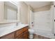 Bright bathroom with a wood vanity, tub and shower combo, and decorative mirror at 270 North St, Salisbury, NC 28147