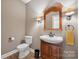 Cozy half bathroom features a wooden vanity, decorative mirror, and standard toilet at 270 North St, Salisbury, NC 28147