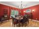 Formal dining room with red walls, hardwood floors, and a decorative chandelier at 270 North St, Salisbury, NC 28147