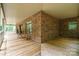 Wide, covered brick porch with wood floors, rocking chairs, and exterior brick wall with windows at 270 North St, Salisbury, NC 28147