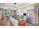 Bright kitchen featuring white cabinetry, a center island with seating, and a dining area with lots of natural light at 270 North St, Salisbury, NC 28147