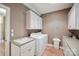 Well-lit laundry room with built-in storage cabinets, utility sink, and washer and dryer at 270 North St, Salisbury, NC 28147