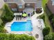 Aerial view of a sparkling pool with lounge chairs and a fire pit, perfect for relaxing and entertaining outdoors at 2812 Julian Glen Cir, Waxhaw, NC 28173