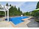 In-ground swimming pool surrounded by lush landscaping and mature trees at 2812 Julian Glen Cir, Waxhaw, NC 28173