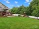 Large backyard featuring an outdoor kitchen, inground pool, tiki bar, and lush greenery for ultimate relaxation at 3038 Sterling Ct, Fort Mill, SC 29707