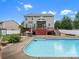 Spacious backyard with a large swimming pool, stone grill area, and a wooden deck at 3038 Sterling Ct, Fort Mill, SC 29707