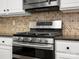 Close up of stainless-steel oven in kitchen with tiled backsplash and light cabinets at 3038 Sterling Ct, Fort Mill, SC 29707