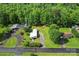 An aerial view shows a home with a gravel driveway nestled among mature trees at 320 E Pine St, Maiden, NC 28650