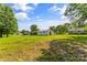 Sprawling backyard showcasing ample green space, blue skies, and surrounding trees at 320 E Pine St, Maiden, NC 28650