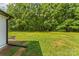 Backyard view of green grass and lush trees at 320 E Pine St, Maiden, NC 28650