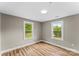 Bright bedroom with hardwood floors, neutral walls, and natural light from the two windows at 320 E Pine St, Maiden, NC 28650