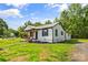 Charming exterior view of home showcasing the metal roof and manicured yard with mature trees at 320 E Pine St, Maiden, NC 28650