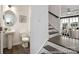 Stylish half-bathroom featuring a pedestal sink, oval mirror, and wood-look flooring, adjacent to the staircase at 32562-B Millingport Rd # 7155, New London, NC 28127