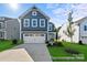 Charming two-story home with a blue exterior, manicured lawn, and an attached two-car garage at 32562-B Millingport Rd # 7155, New London, NC 28127