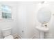 Powder room featuring a pedestal sink, round mirror, and modern fixtures at 32616 Millingport Rd # 7144, New London, NC 28127