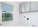 This laundry room features overhead gray cabinets, a bright window, and white walls at 32616 Millingport Rd # 7144, New London, NC 28127