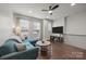 Bright living room featuring hardwood floors, modern ceiling fan, and comfortable blue sofa at 336 Uptown West Dr, Charlotte, NC 28208