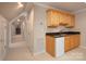 A compact kitchenette features wooden cabinets, a sink, a mini-fridge and is located near a hallway of doors at 3504 High Ridge Rd, Charlotte, NC 29270