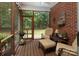 A screened-in porch with comfortable seating, lush greenery, and a view into the wooded yard at 3504 High Ridge Rd, Charlotte, NC 29270