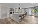 Open-concept kitchen and laundry area with an island, bar stools, and stainless steel appliances at 3528 Colony Rd # A, Charlotte, NC 28211