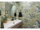 Stylish powder room featuring tropical wallpaper, a modern vanity, and elegant mirror at 3528 Colony Rd # A, Charlotte, NC 28211