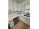 Modern kitchen featuring white cabinets, stainless steel dishwasher, wood floors and updated countertops at 3700 Denson Pl, Charlotte, NC 28215