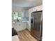 Bright kitchen with stainless steel appliances, white cabinets, marbled backsplash and light wood flooring at 3700 Denson Pl, Charlotte, NC 28215