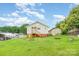 Expansive backyard showcasing the home's exterior, detached garage, and outdoor seating area with a fire pit at 380 Woodlawn Ave, Cramerton, NC 28032