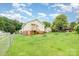 Home featuring a large, fenced backyard, showcasing a fire pit, seating area, and storage shed at 380 Woodlawn Ave, Cramerton, NC 28032
