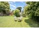 Serene backyard setting with mature trees, well-kept lawn, and a seating area for relaxing at 380 Woodlawn Ave, Cramerton, NC 28032