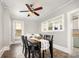 Cozy dining room featuring tiled floors, a farmhouse-style table, and a unique ceiling fan, creating a warm ambiance at 380 Woodlawn Ave, Cramerton, NC 28032
