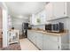 Bright kitchen features gray cabinetry, tile backsplash, and stainless steel appliances at 380 Woodlawn Ave, Cramerton, NC 28032