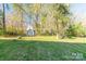 Spacious backyard featuring a well-maintained lawn, mature trees, and a storage shed perfect for outdoor activities at 3921 Bon Rea Dr, Charlotte, NC 28226