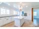 Bright kitchen featuring white cabinets, a large island, stainless steel appliances, and stylish light fixture at 3921 Bon Rea Dr, Charlotte, NC 28226